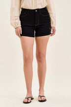 High-waist black denim shorts with gold star studs and button closure