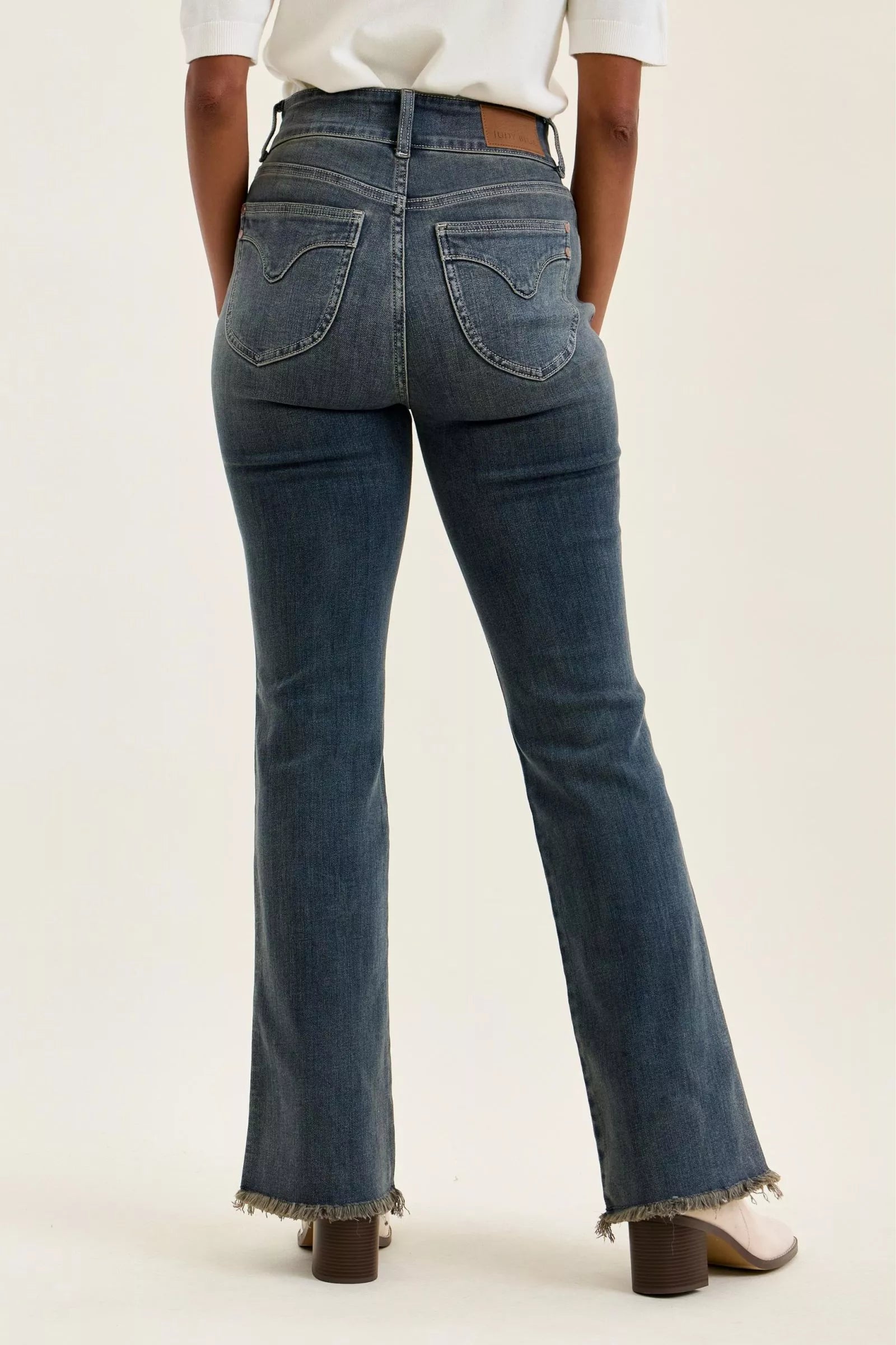 High-waist straight dark blue jeans with frayed cuffs and visible back pockets