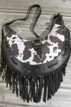 Cow print faux leather fringe hobo bag with metal buckle front and dangling tassels