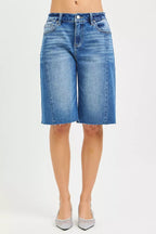 Medium-wash denim jorts with raw frayed hem and button fly front