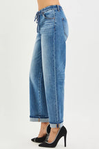 Medium-wash slouch ankle jeans with cuffed hem and back drawstring detail