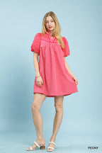 Pink textured eyelet babydoll mini dress with puff sleeves and V neckline, above-knee