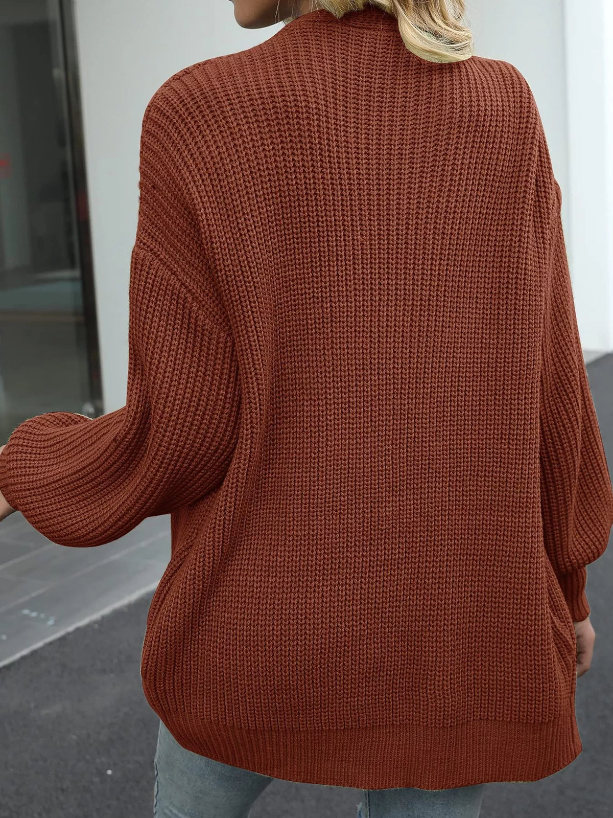 Chunky knit cardigan with lantern sleeves, ribbed crew neck, warm brown color.