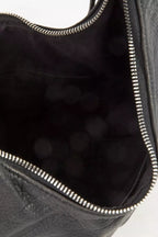 Close-up of black crescent shoulder bag interior with top zipper and stitched trim