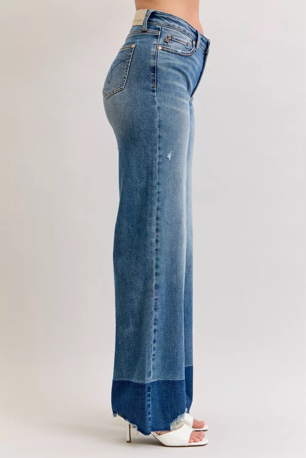 High-waist straight jeans in medium blue denim, back view with raw hem