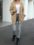 Chunky knit cardigan with long lantern sleeves, beige open front.