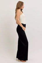High-waisted wide-leg black denim jeans, side profile with belt loops and ankle-length