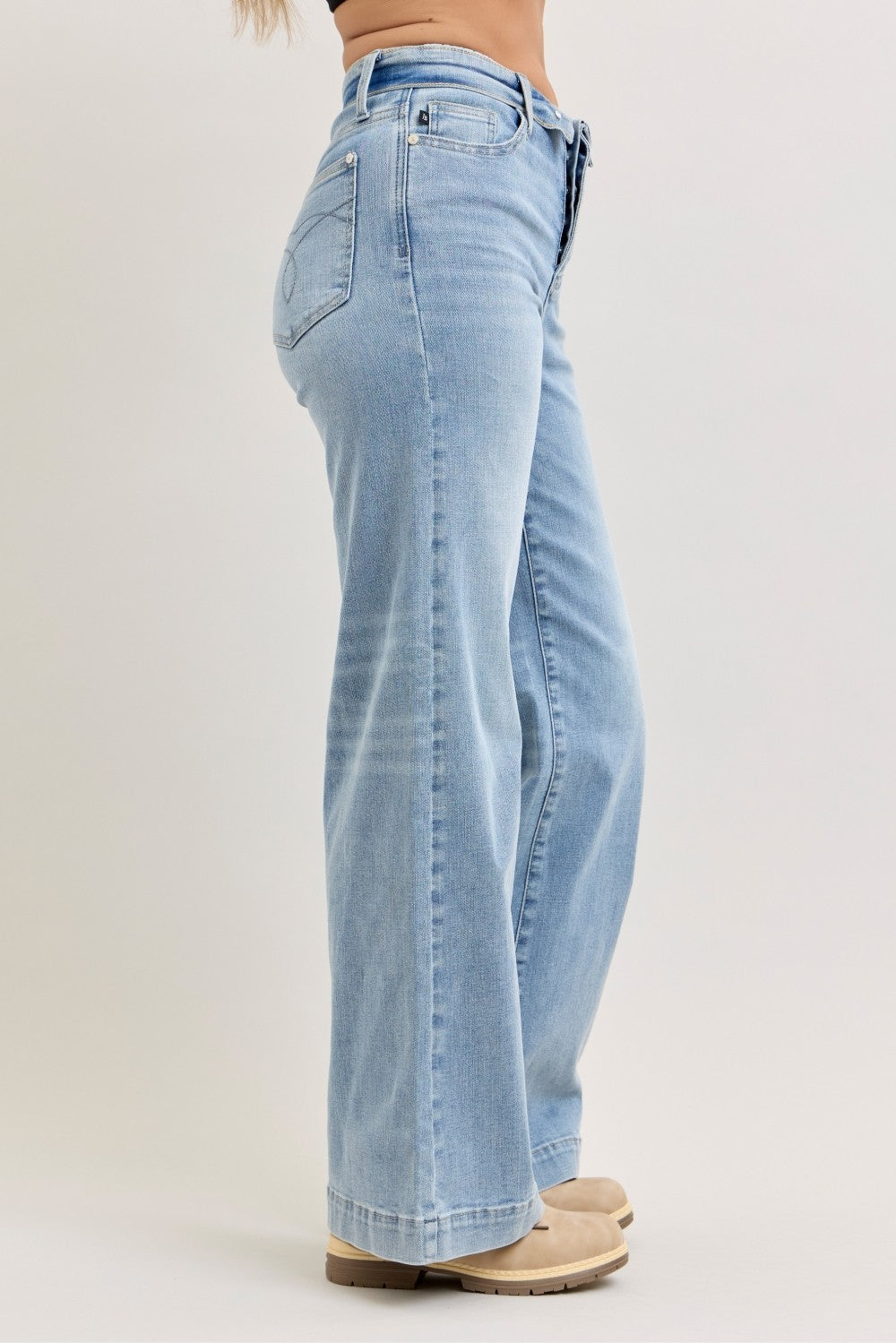 Light wash mid-rise wide-leg jeans, side view with button fly