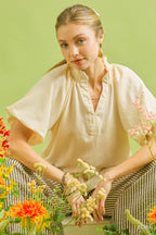 Ecru textured blouse with gathered neckline and floral lace trim