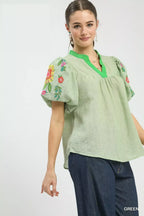 Light green puff-sleeve top with floral embroidery on sleeves and V-neck