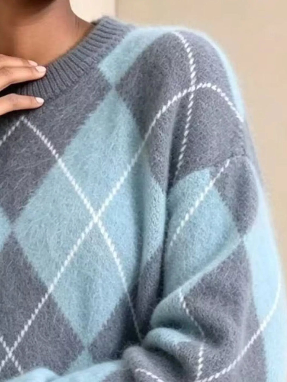 Fuzzy argyle knit sweater sleeve detail in light blue and gray with white diamonds