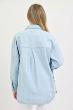 Light blue denim shacket with yoke seam and buttoned cuff