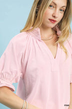 Pink textured V-neck blouse close-up with ruffle collar