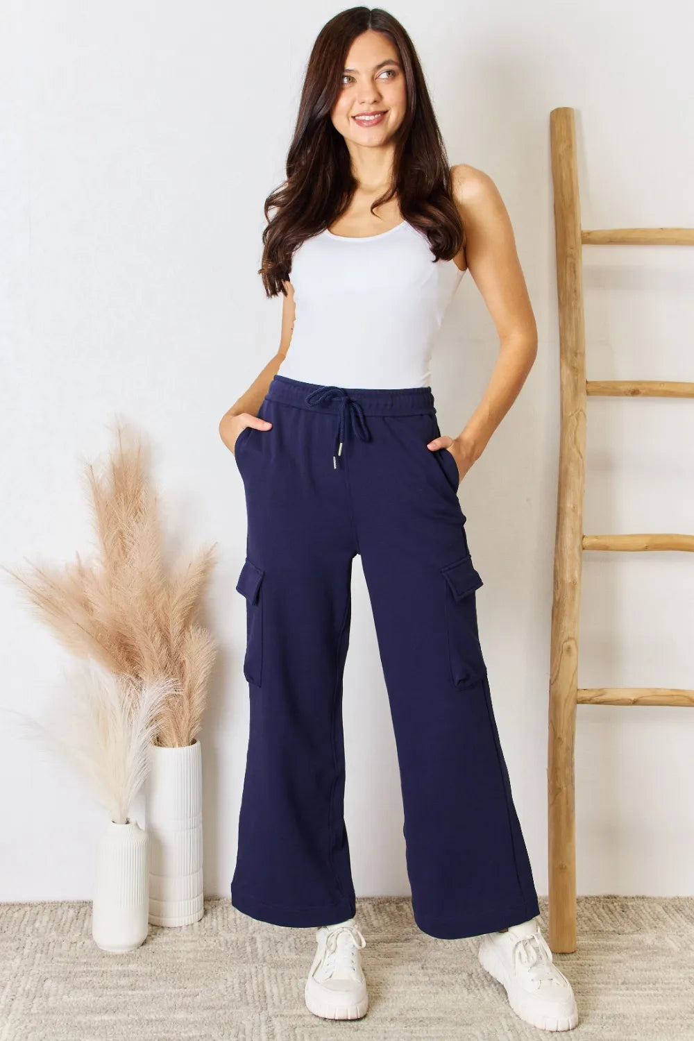 Dark blue drawstring cargo pants with wide legs and side flap pockets
