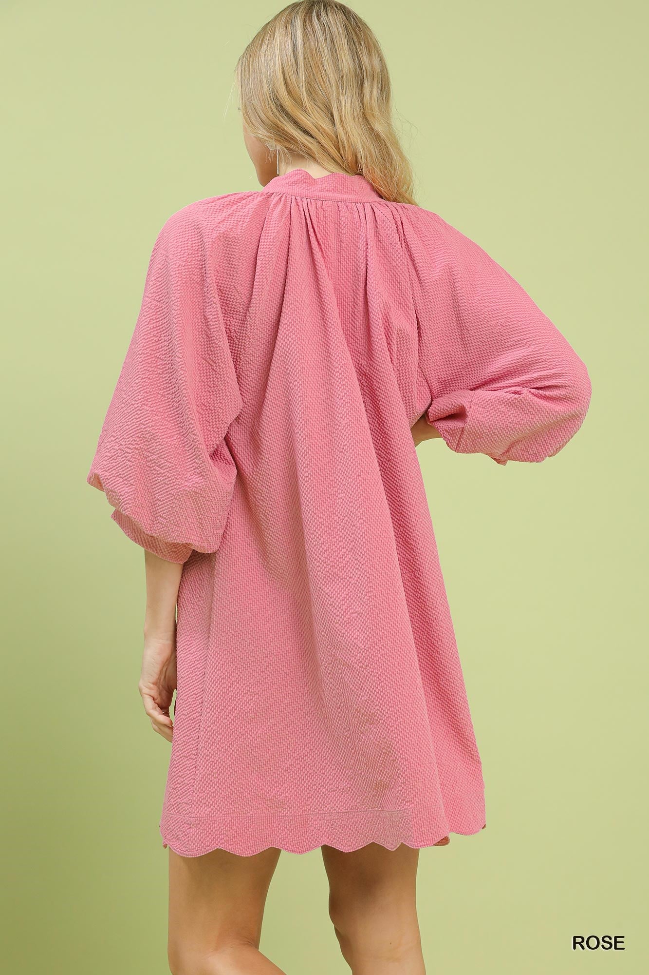 Rose pink textured mini dress with gathered back yoke and balloon sleeves, scalloped hem