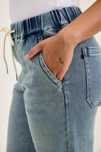 Medium-wash denim with drawstring elastic waist and front V-shaped seam detail