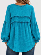 Back view of teal peplum blouse with frayed trim and gathered balloon sleeves