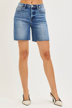 Medium-wash high-rise denim shorts with raw hem, button fly, front pockets.
