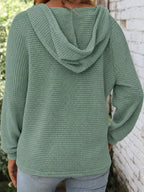 Back view of sage green waffle-knit button hoodie with hood and long sleeves.