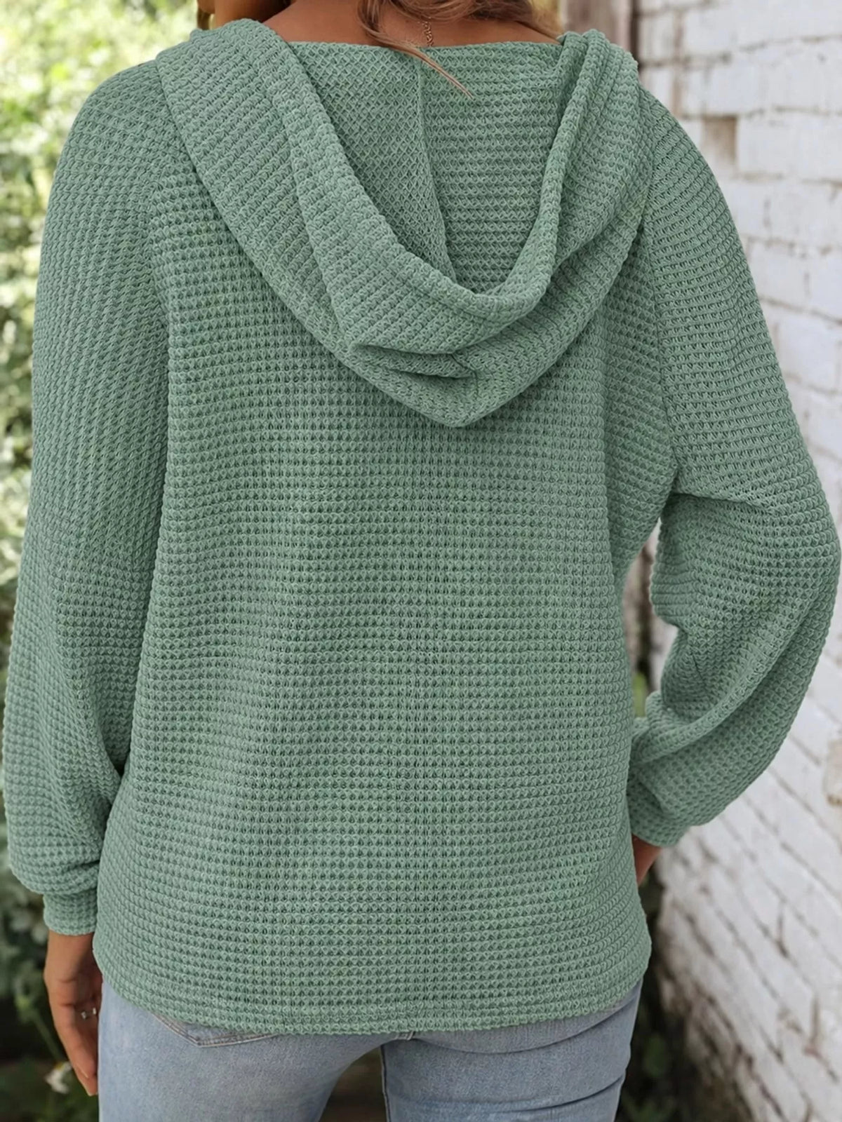 Back view of sage green waffle-knit button hoodie with hood and long sleeves.