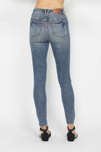 Medium wash skinny jeans, back pockets with belt loops, five-pocket fit, button-zip closure.