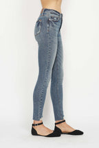 Medium wash skinny jeans with distressed hem and back belt loops, ankle-length cuff.