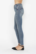 Medium wash skinny jeans with distressed pocket detail and belt loops, button-zip closure.