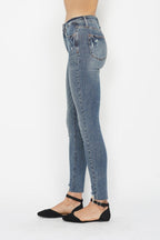 Medium wash skinny jeans with side seam stitching and distressed back yoke, button-zip closure.